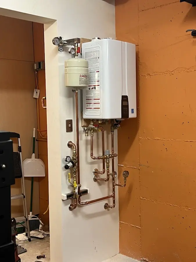 Plumbing technician inspecting water heater connections in Nampa